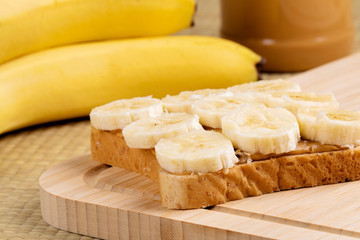 Peanut butter and banana sandwich on a wooden background