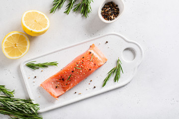 Salmon. Raw Trout Red Fish fillet served with Herbs, lemon, cherry tomatoes and spicies on white...