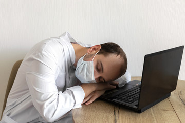 young doctor in mask asleep on desk