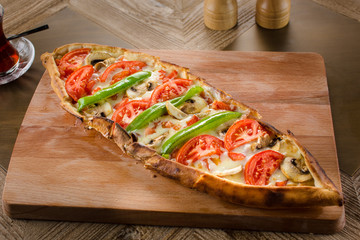 Turkish vegetarian pide with vegetables on wooden table