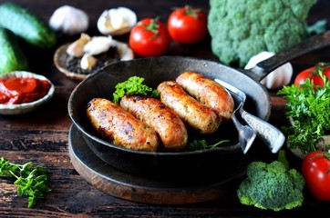 Homemade chicken (turkey) sausages fried in a pan. picnic. rustic