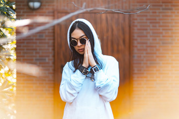 Young women with praying hands and sunglasses in handcuffs