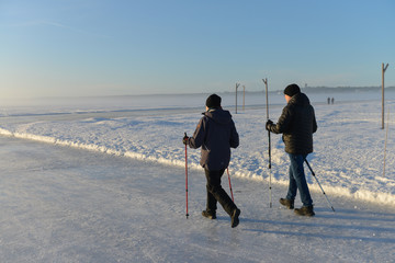 balade d'un couple âgée sur la mer gelée  et enneigée du nord arctique dans la ville de  Luleå en Suède