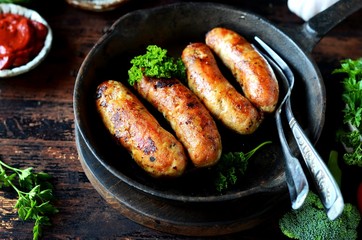 Homemade chicken (turkey) sausages fried in a pan. picnic. rustic