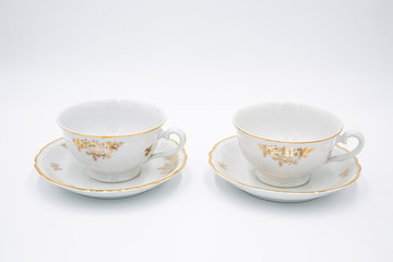 Vintage white  tea cups  with golden design in classic style isolated on white backg