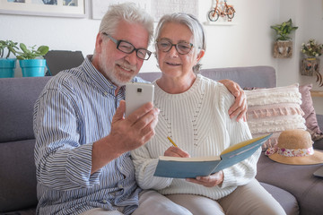 Senior happy couple having fun together with smart phone. Concept of active and modern elderly people during retirement