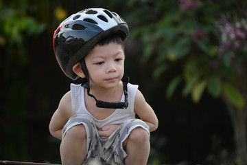 Fototapeta na wymiar cute child wear sport helmet for playing bicycle in the park