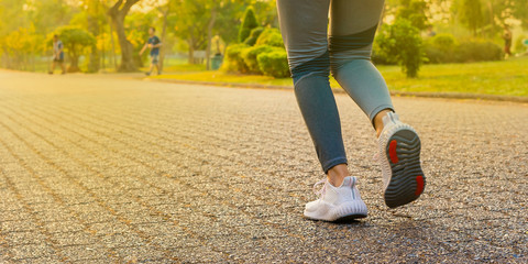 young woman runner running at road with orange light 