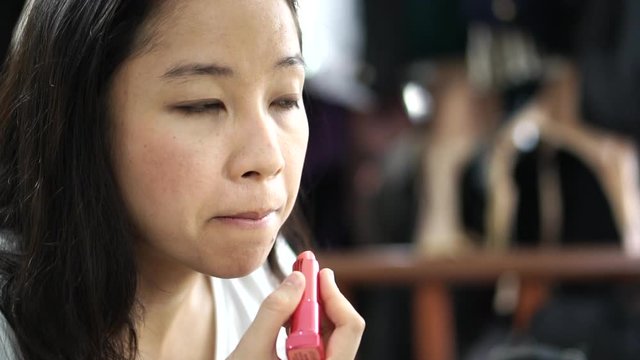 Asian Woman Do Pink Lipstick Make Up On Her Face Close Up