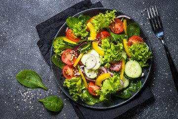 Fresh vegetables salad on black.