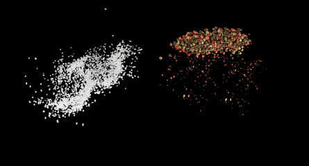 Salt and whole coloured pepper spice flying in the air close up. Zero gravity concept.