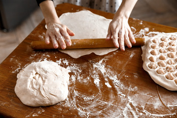 Young girl preparing dough for baking or dumplings in sunny time