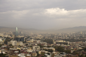 Fototapeta na wymiar Sun trying pass through smog above the Tbilisi - capital of Georgia