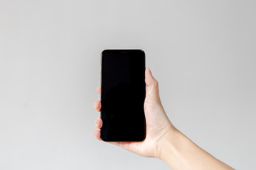 Fototapeta na wymiar hand holding mobile phone isolated on white