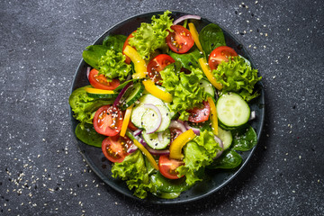 Fresh vegetables salad on black.