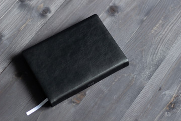 Paper note book in black cover for 2020 year on wooden background