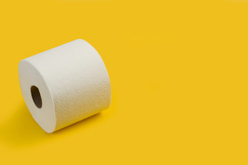 Rollo de papel higiénico sobre fondo amarillo liso brillante. Vista superior. Copy space