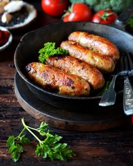 Homemade chicken (turkey) sausages fried in a pan. picnic. rustic
