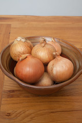 Bulb onions or common onions in a rustic pot