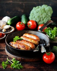 Homemade chicken (turkey) sausages fried in a pan. picnic. rustic