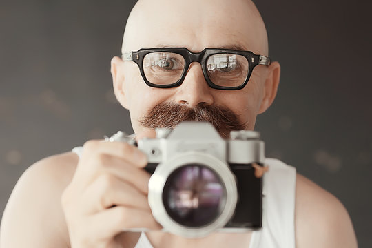 photographer with a vintage analog camera, a man with mustache, funny image learning photography