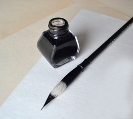 Ink bottle with brush for painting calligraphy on white