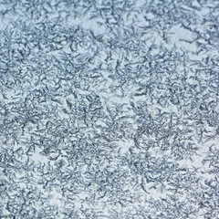 White frost crystals pattern close-up background texture on glass