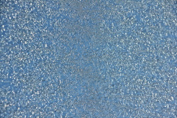 Blue hoarfrost background texture on glass on sky backdrop