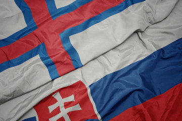 Fototapeta premium waving colorful flag of slovakia and national flag of faroe islands.