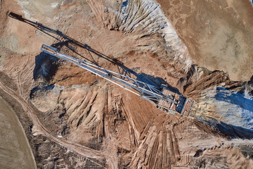 big excavator dripping earth in a quarry