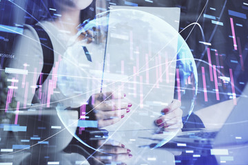 Double exposure of hands making notes with forex chart huds. Stock market concept.