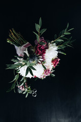 Wedding bouquet of white chrysanthemums and purple roses on a dark background