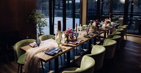 Table design for dinner at a restaurant with purple flowers and green chairs