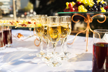 Elegant glasses with champagne standing on serving table during celebration