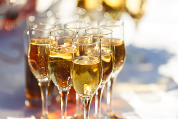Elegant glasses with champagne standing on serving table during celebration