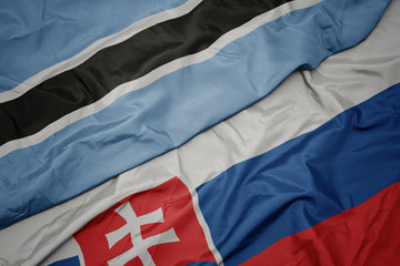 waving colorful flag of slovakia and national flag of botswana.