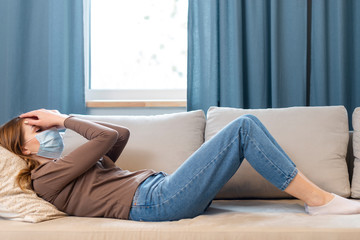 Long shot woman with mask staying on the couch