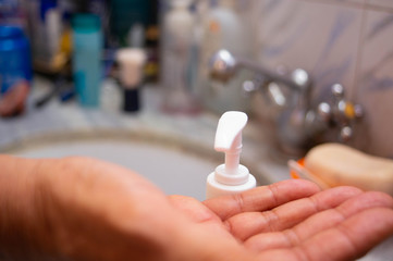 A person applying liquid soap or sanitizer on his hands