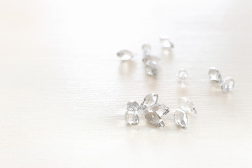 Beautiful crystal drops beads over white wooden background