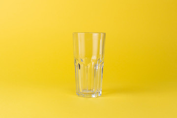 Empty glass cup on a yellow background