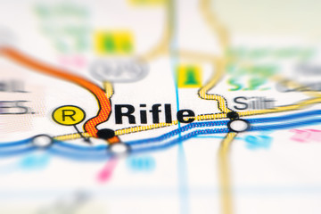 Rifle on a USA printed road map. Close-up on road map. Target of journey.