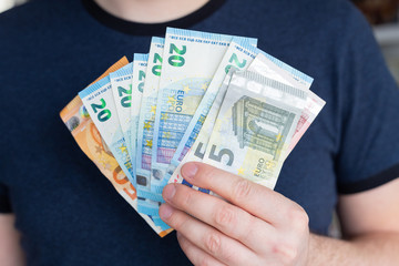 Euros in man's hands. Profits, savings Success, motivation, financial flows, wealth. Stack of euros Crisis Lack of money