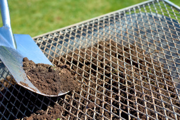 Compost sieve with a shovel and a wheelbarrow