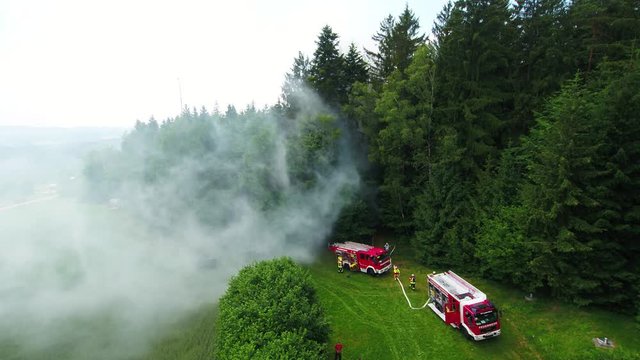 fire engines and firefighters close to forest fire