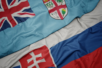 waving colorful flag of slovakia and national flag of Fiji .