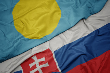 waving colorful flag of slovakia and national flag of Palau .