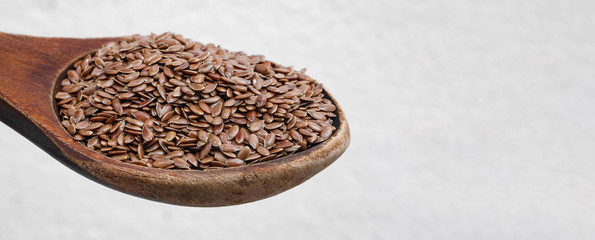 Panoramic shot with focus on flax on a wooden spoon. Eco-friendly product for digestion and stomach