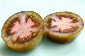 Detalle de un tomate kumato negro cortado a la mitad. Solanum lycopersicum.