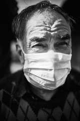 black and white photo of an elderly man in a white mask