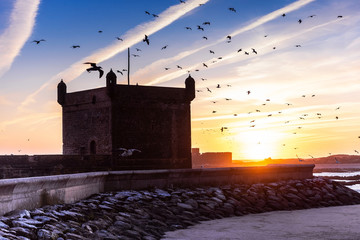 View of the silhouette from the old Fort Essaouira, Sqala du Port, at sunset, blue sky, background...